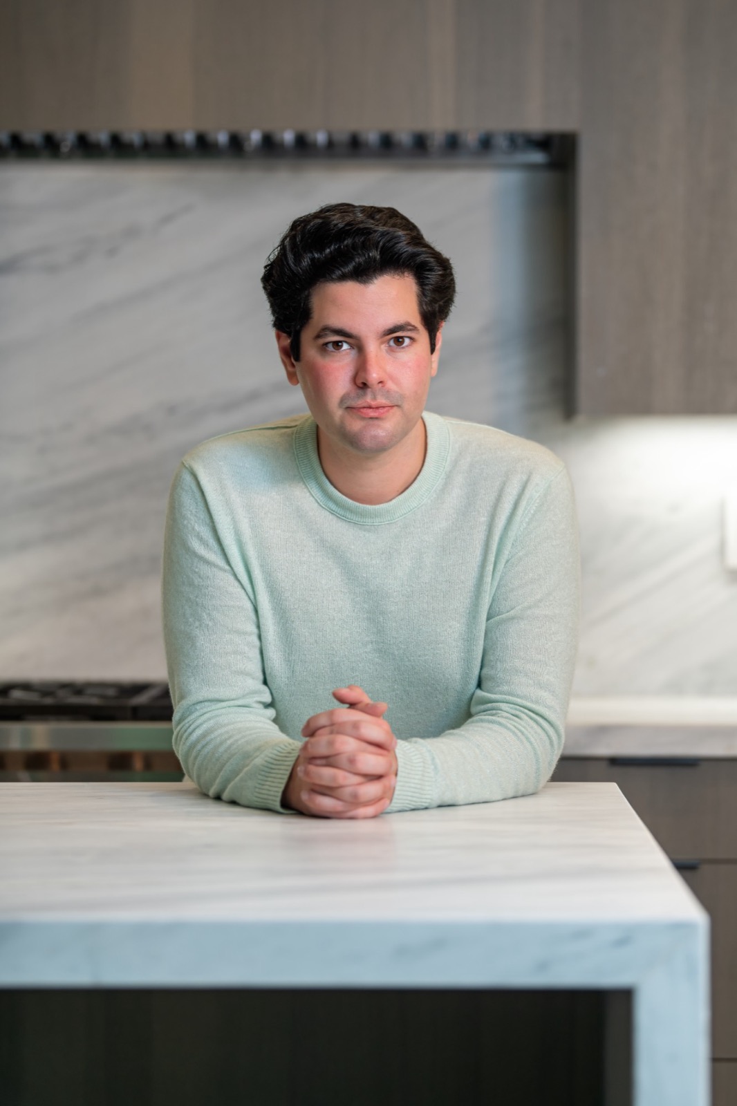 Brandon White, seated at a marble kitchen island in soft daylight.