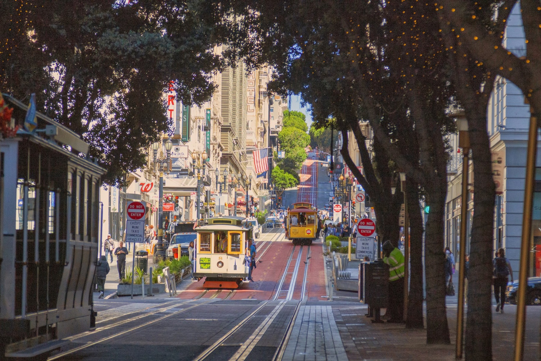 A cable car climbing a city street.